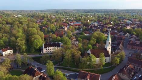 вид с воздуха на старый город кулдиги с красной черепицей на крыше и евангелическо-лютеранскую церковь святой катерины в кулдиге, латвия