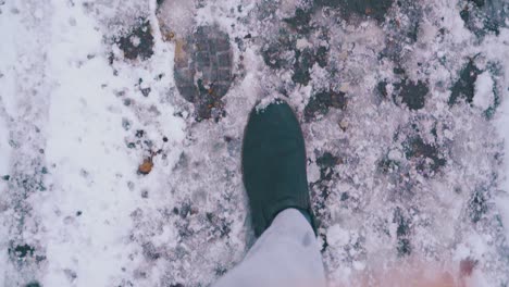 Füße-In-Grauen-Hosen-Laufen-Auf-Einer-Asphaltstraße-Mit-Geschmolzenem-Schnee