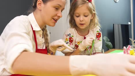madre e hija coloreando huevos de pascua
