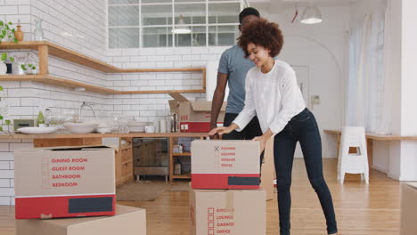 Smiling Young Couple Carrying Boxes Into New Home On Moving Day