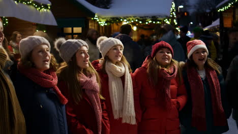 women's choir singing christmas carols outdoors