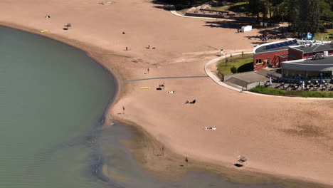 telephoto drone shot circling the quiet hietaniemi beach, summer day in helsinki