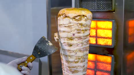 chef skillfully slicing meat shawarma from vertical rotisserie