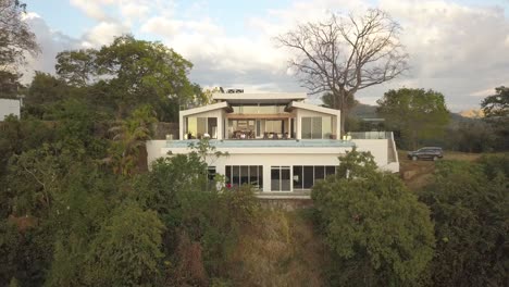 epic drone flying back from luxury villa in lush mountains with infinity pool