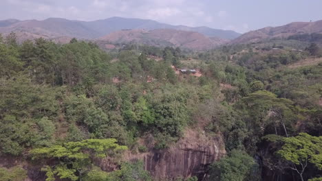 Low-aerial-flight-to-cliff-top-farm-buildings-in-Malawi-Africa