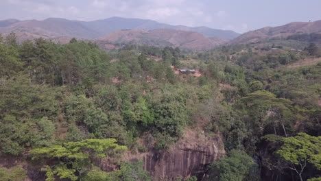 low aerial flight to cliff top farm buildings in malawi africa