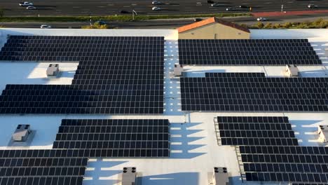 instalación de paneles solares en la azotea de un edificio comercial vista aérea ascendente para revelar el intenso tráfico de la autopista