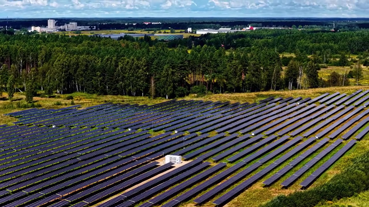 Luftfoto af solcellepark med justerede solcellepaneler i landligt landskab, drone.