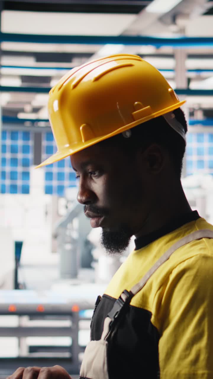 Vertical Video Photovoltaics factory technician optimizing production flow using laptop