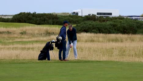 dos hombres jugando al golf en un campo