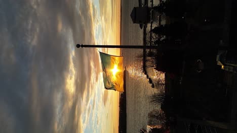 bandera de ucrania en cámara lenta durante un amanecer en un asta de bandera, video vertical
