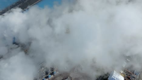 fotografía aérea de una central geotérmica con pozos artificiales y humo flotante