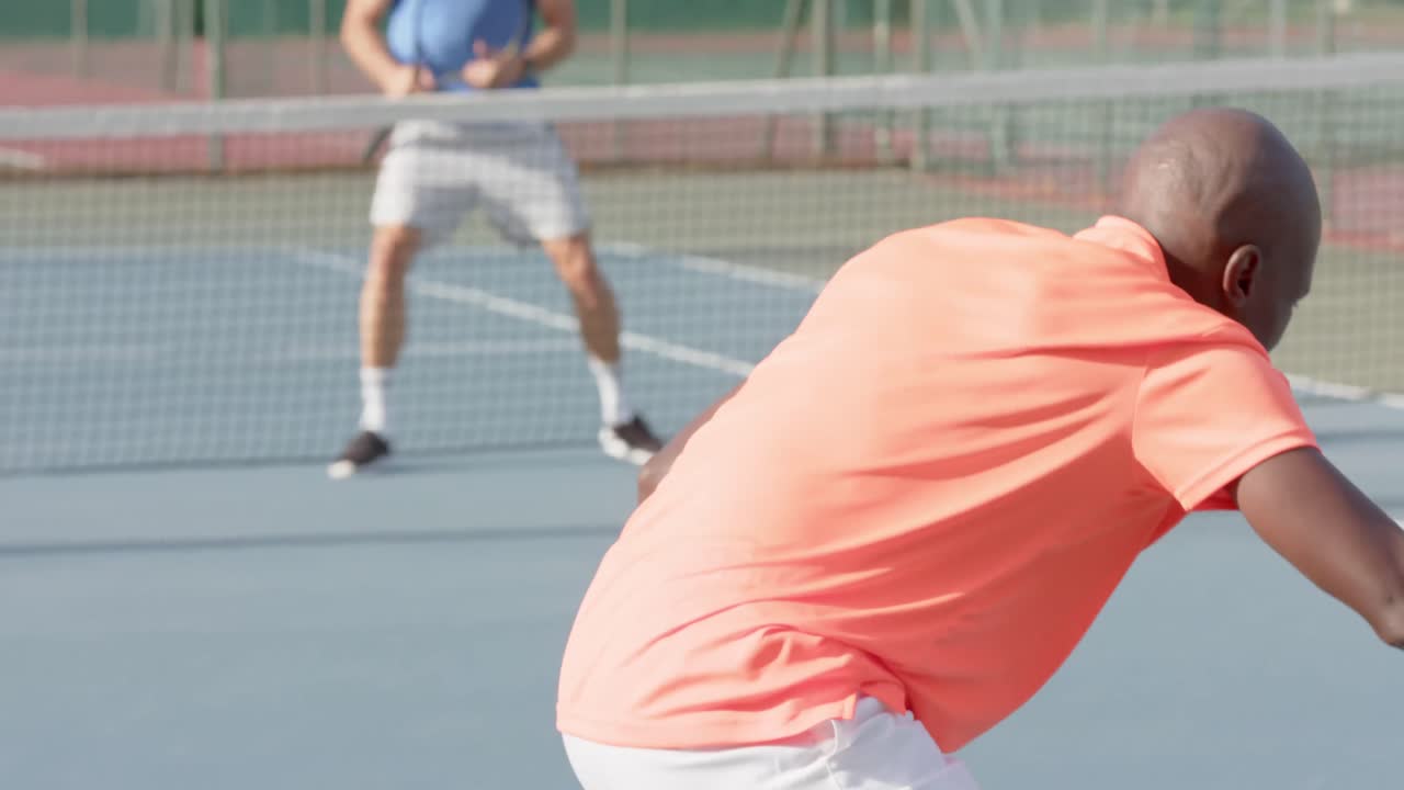 Caucasian male tennis player celebrating point against diverse opponent on court in slow motion