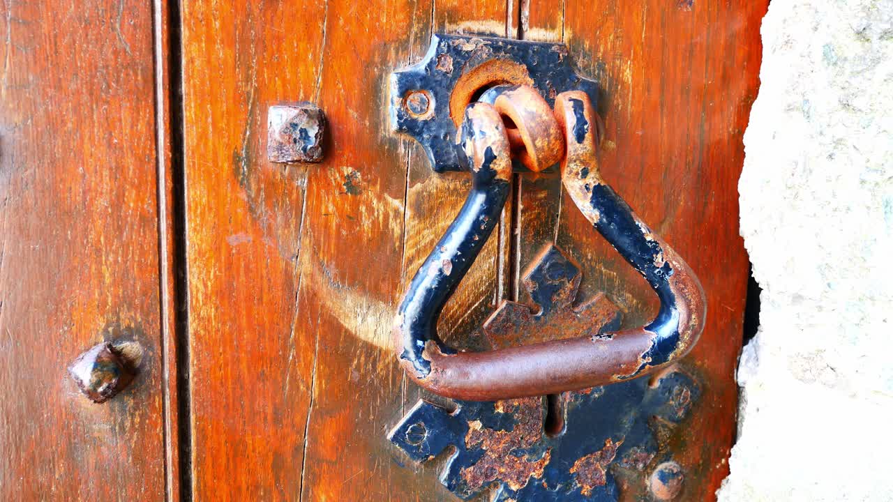 무거운 나무 판자는 금속 스터드 못 잠금 장치가 있는 풍화 중세 문과 핸들 돌리 오른쪽 근접 촬영을 처리합니다.