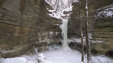 Natürliche-Klippe-Und-Gefrorener-Wasserfall-Bei-Leichtem-Schneefall,-Wintersaison