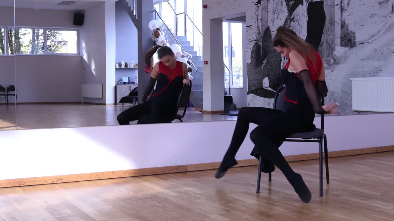 профессиональная танцовщица танцует вокруг стула перед зеркалом