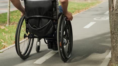 man with disabilities in wheelchair walk at the park alley