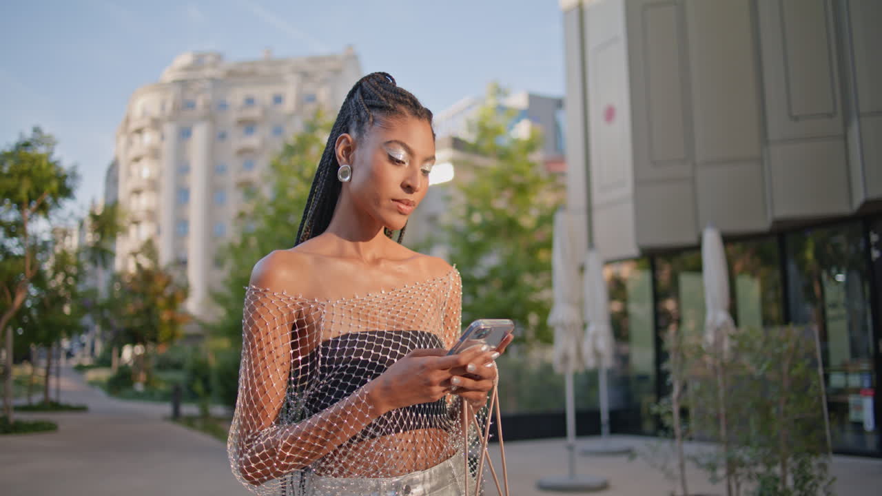 Donna rilassata con il cellulare in mano che cammina per strada, primo piano. Donna felice che attraversa.