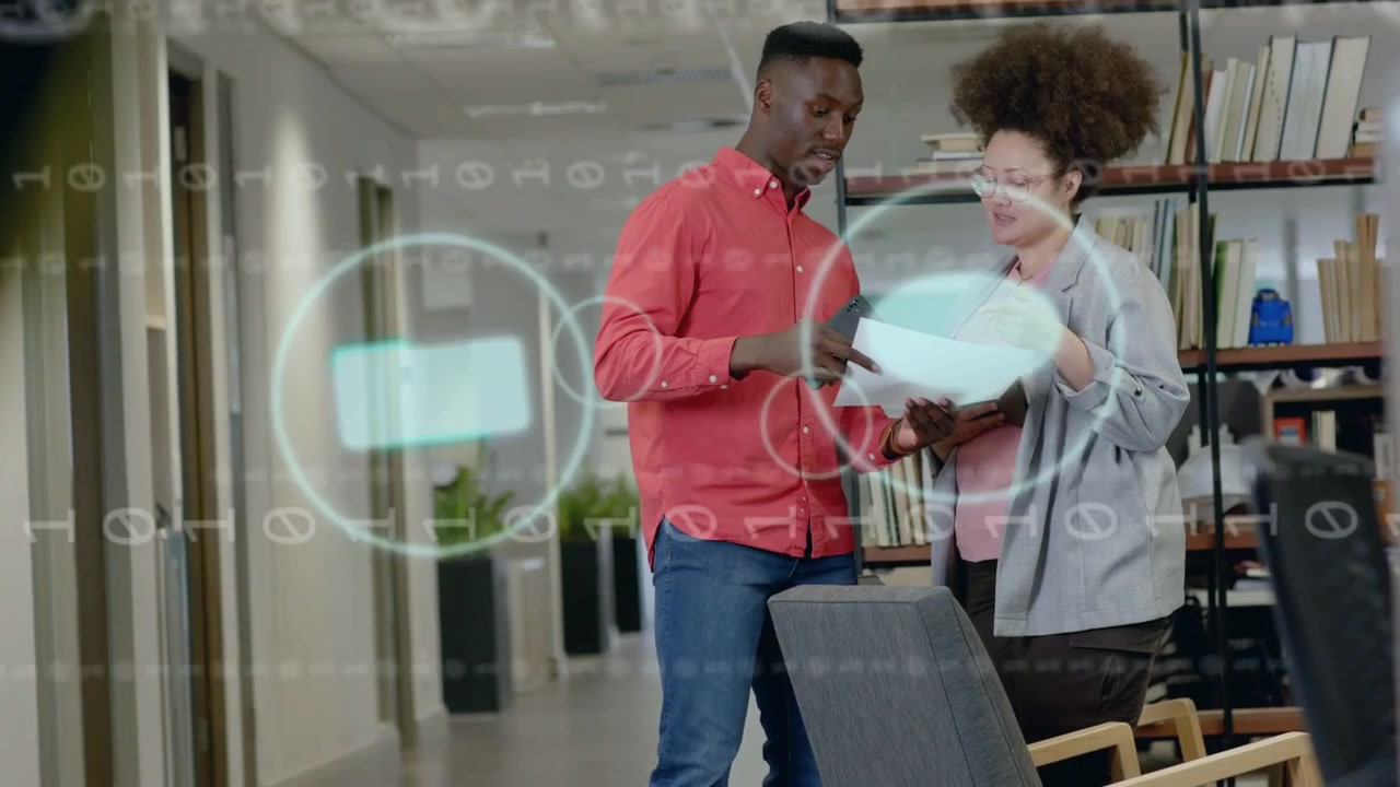 Two staff tapping tablet and pointing paper in office, icons appearing then fading, guiding review