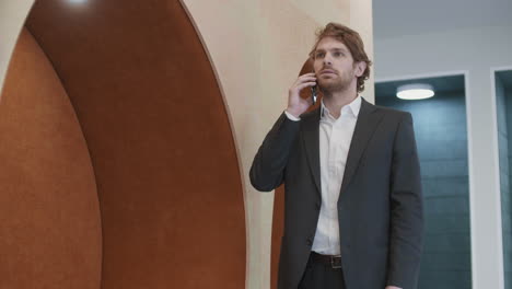 young caucasian businessman having telephone call in office