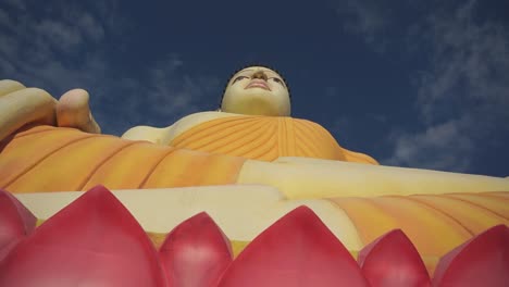 upward moving shot of very large buddha statue