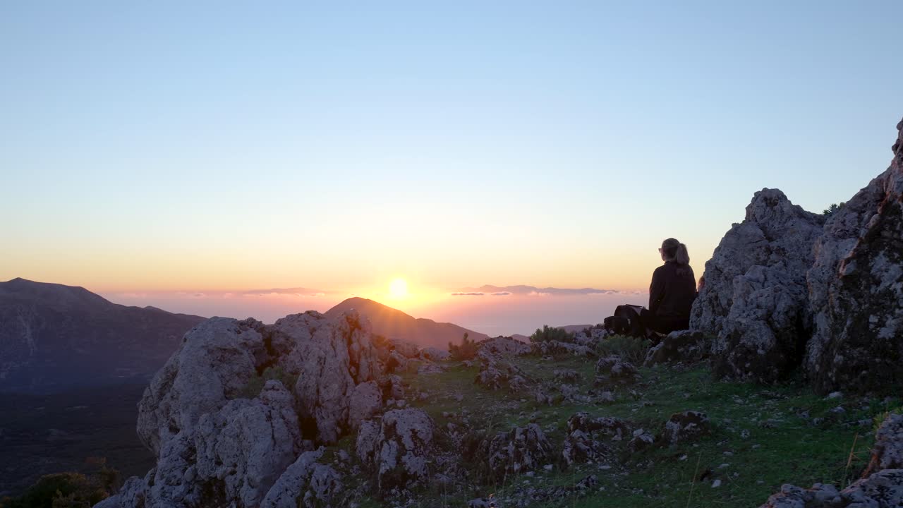 Vista del tramonto dalla cima di una montagna con una persona