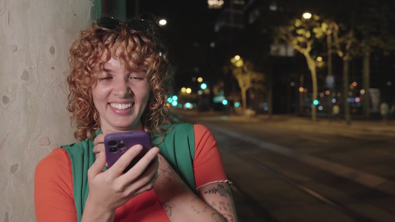 A woman using a mobile phone at night in the city