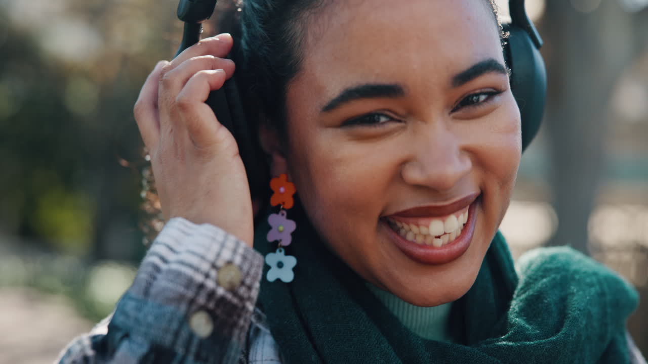 Woman with headphones smiling outdoors