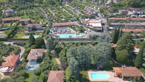 aerial reverse shot of swimming pool at camping eden in lake garda, italy