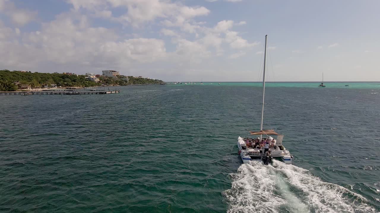 un gran grupo de turistas en un yate catamarán navegando en el océano