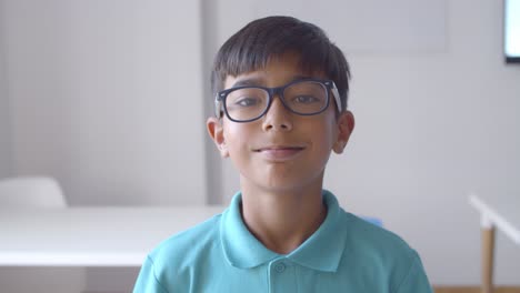 niño de escuela latino positivo que lleva gafas