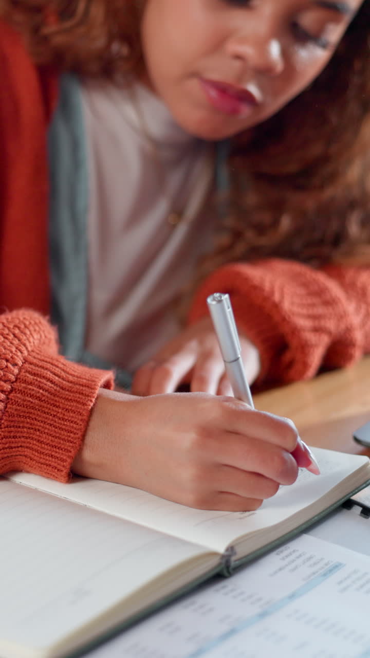 Young Woman Writing Notes in a Notebook While Studying