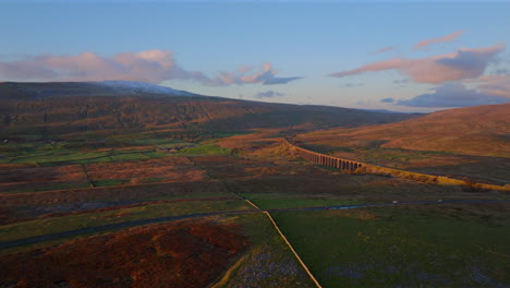 Establecimiento-De-Una-Toma-Aérea-Con-Drones-Del-Viaducto-Riblehead-Y-La-Montaña-Nevada-De-Whernside-Al-Atardecer-De-La-Hora-Dorada-En-Yorkshire-Dales,-Reino-Unido