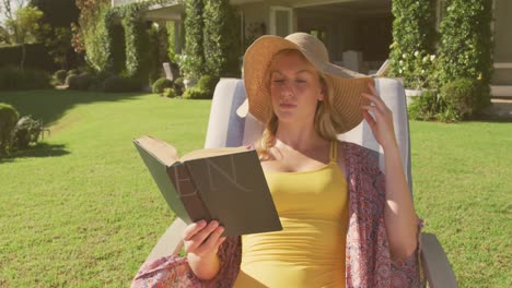 animation of enjoy text over caucasian woman reading book