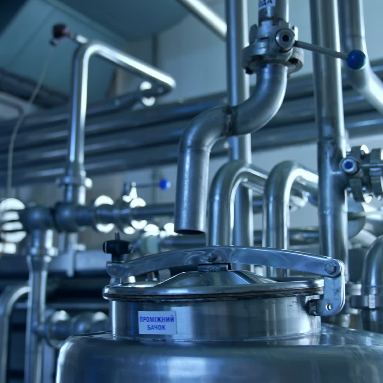 Industrial Milk Production Facility. Modern steel machines at industrial conveyor line of soft drink production plant