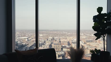 looking out the windows of a high rise condo building in a downtown city showing the landscape below, tight push in