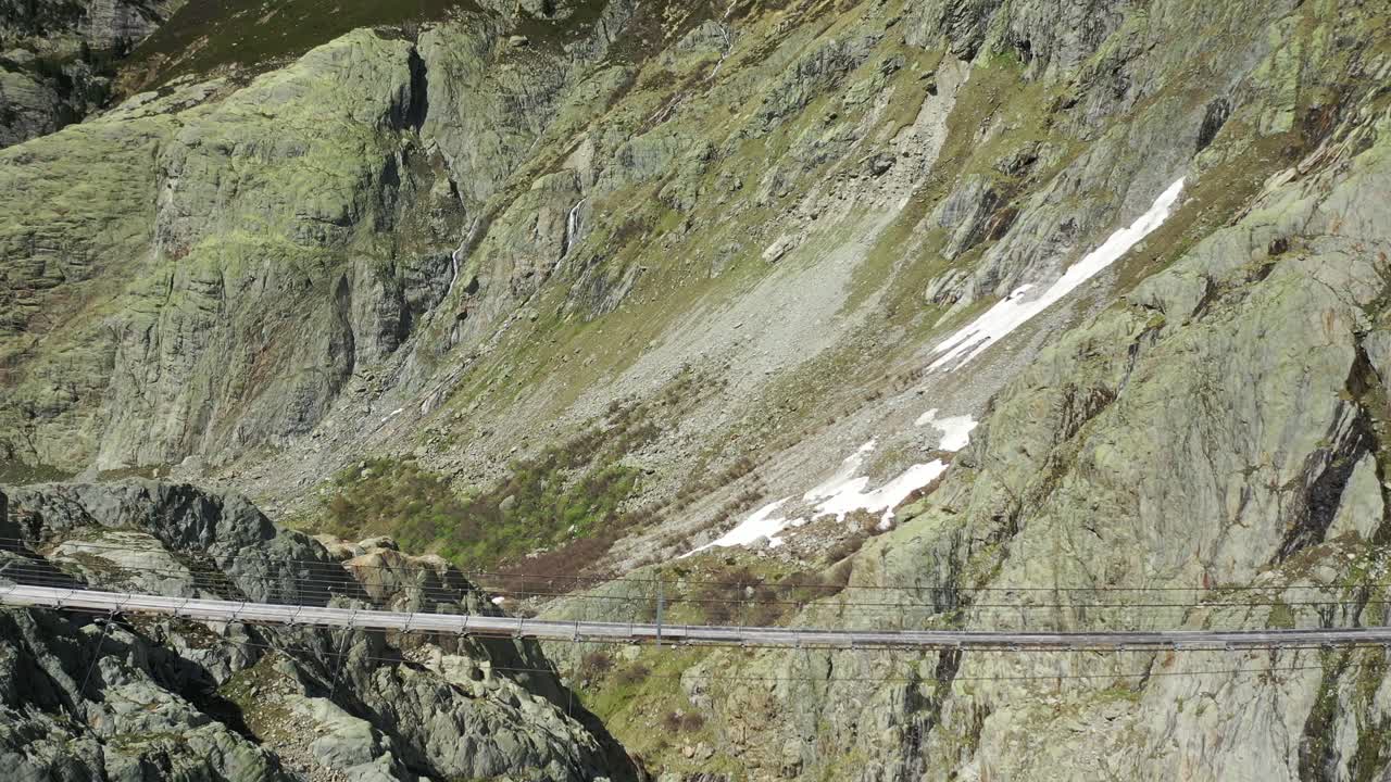 toma aérea de un puente colgante de madera en los alpes durante un hermoso día de verano