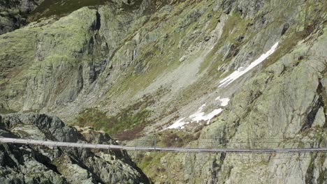 Aerial-dolly-shot-of-Woodenwooden-Swinging-Bridge-in-alps-during-beautiful-summer-day