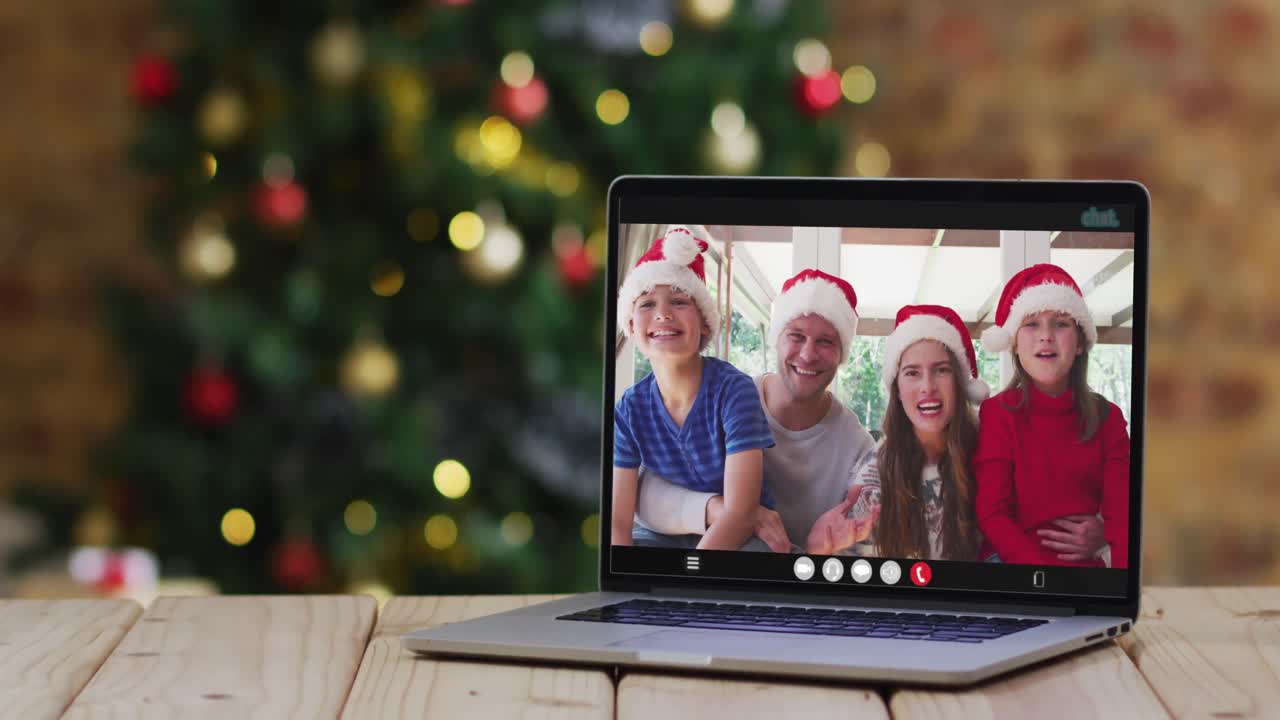 familia feliz usando sombreros de santa en una llamada de video portátil, con decoraciones de navidad y árbol