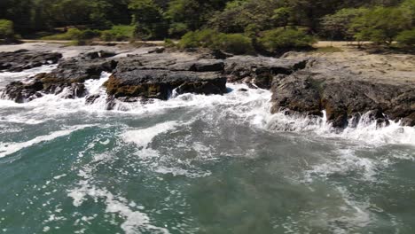 rocky stone coast with waves splashing aginst the stones dji drone shot filmed in costa rica