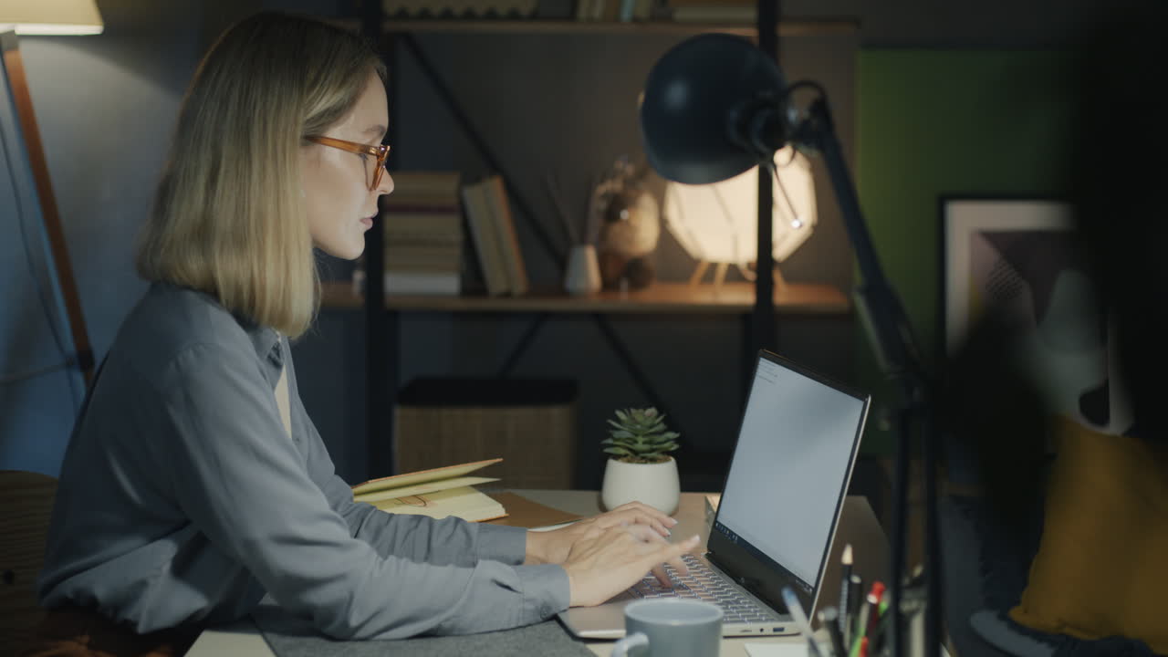 mujer trabajando en la computadora portátil por la noche
