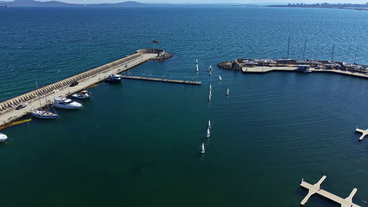 Veleros y yates atracados en un puerto deportivo en un día soleado junto a la costa cerca de la ciudad.