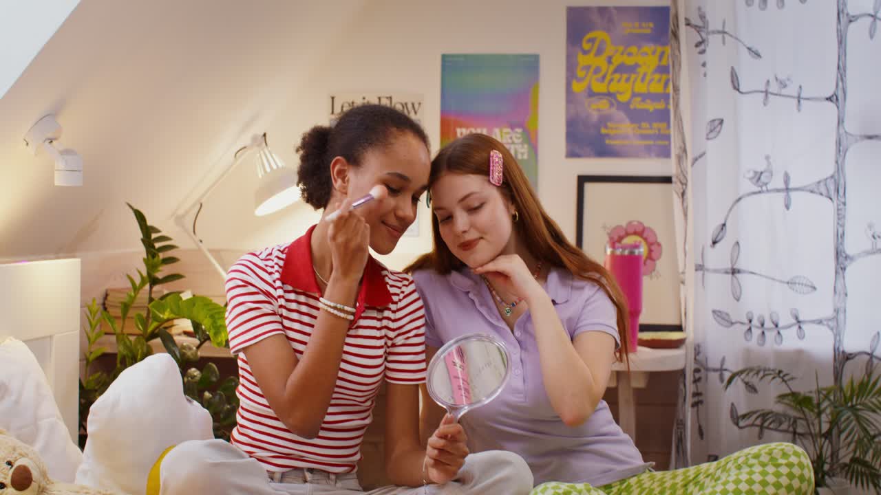 chicas adolescentes aplicando maquillaje en un dormitorio