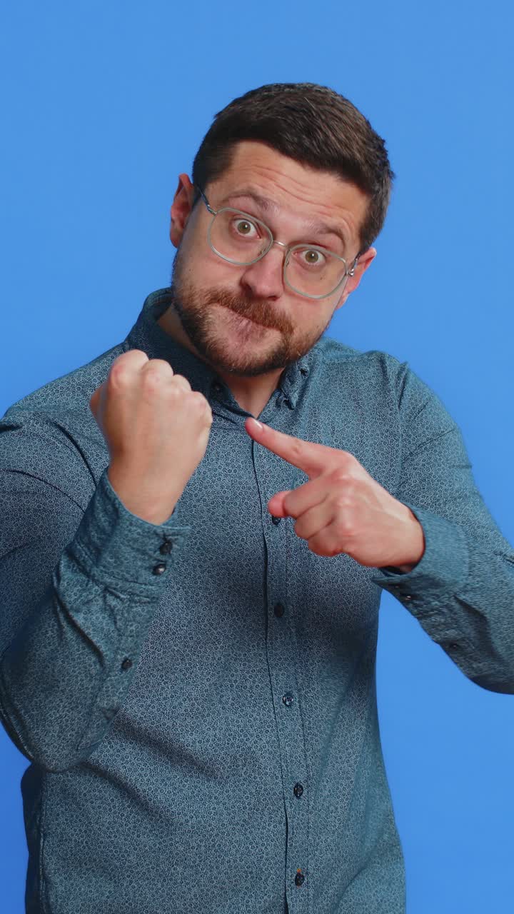 공격적인 분노한 남자가 카메라 앞에서 싸우려고 주먹을 흔들고 권투 처벌을 위협합니다.