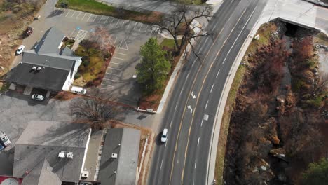 Aerial-flyover-of-cars-driving-through-sleepy-mountain-town