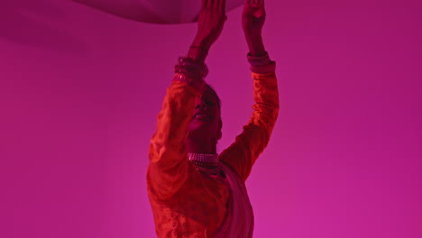 Studio-Shot-Of-Female-Kathak-Dancer-Performing-Dance-Wearing-Traditional-Indian-Dress-Against-Purple-Background