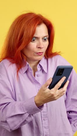 woman with red hair reacting to content on her smartphone