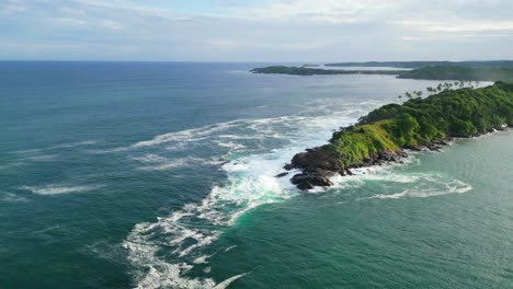 A-boat-making-it's-way-through-the-rough-waters-in-front-of-cliffs-in-Sri-Lanka