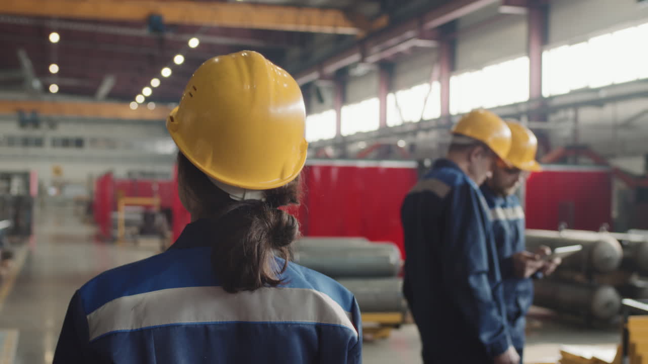 Rear View Of Female Supervisor Walking Through Plant Facility