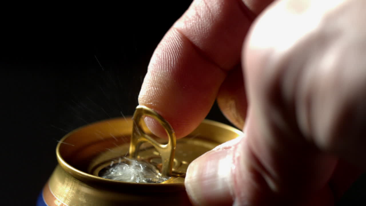 la mano abriendo una lata de refresco